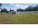 View of the grass backyard with storage shed and white fence surrounding the yard at 181 Coconut St, Punta Gorda, FL 33980