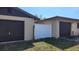 Exterior view between garages with a white vinyl fence at 181 Coconut St, Punta Gorda, FL 33980