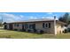 Charming single-story home with a well-manicured lawn, dark shutters, and a neutral color palette at 181 Coconut St, Punta Gorda, FL 33980