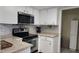 Modern kitchen with stainless steel appliances, light countertops, white cabinetry, and decorative backsplash at 181 Coconut St, Punta Gorda, FL 33980