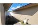 Side yard of the home showing the exterior wall, fence, and ground conditions at 181 Coconut St, Punta Gorda, FL 33980