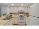 A functional kitchen featuring white cabinets and appliances, offering a clean and efficient space at 19505 Quesada Ave # O104, Port Charlotte, FL 33948