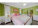 Green-walled bedroom with pink bedding and white furniture at 20 Medalist Cir, Rotonda West, FL 33947