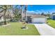 Single-story house with attached garage,palm trees and well-maintained lawn at 20 Medalist Cir, Rotonda West, FL 33947