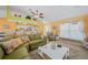 Bright living room with open floor plan, green couches and kitchen at 20 Medalist Cir, Rotonda West, FL 33947