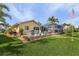 Landscaped backyard with patio, lush lawn, and canal view at 2198 El Cerito Ct, Punta Gorda, FL 33950