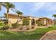 Tan house with metal roof, palm trees, and a landscaped yard at 2198 El Cerito Ct, Punta Gorda, FL 33950