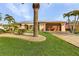 Tan house with metal roof, palm trees, landscaped yard, and paved driveway at 2198 El Cerito Ct, Punta Gorda, FL 33950