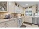 White kitchen with stainless steel appliances and a tile backsplash at 2198 El Cerito Ct, Punta Gorda, FL 33950