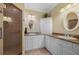 Bright bathroom with double sinks, stone countertops, custom cabinets and a glass enclosed shower at 3329 Purple Martin Dr # 113, Punta Gorda, FL 33950
