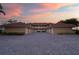 Condo exterior featuring attached garages, paved driveways, and a beautiful sunset backdrop at 3329 Purple Martin Dr # 113, Punta Gorda, FL 33950