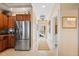 Kitchen area adjacent to a hallway with stainless steel refrigerator and overhead storage at 3329 Purple Martin Dr # 113, Punta Gorda, FL 33950