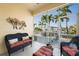 Charming screened lanai showcasing stylish wicker furniture and a view of lush palm trees at 3329 Purple Martin Dr # 113, Punta Gorda, FL 33950