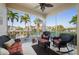 Comfortable screened lanai featuring wicker furniture and stunning views of palm trees and waterway at 3329 Purple Martin Dr # 113, Punta Gorda, FL 33950