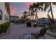 Waterfront condo patio featuring a grill, seating, and views of palm trees and a canal at 3329 Purple Martin Dr # 113, Punta Gorda, FL 33950