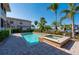 Outdoor pool and hot tub with brick surround complemented by palm trees and manicured landscaping at 3329 Purple Martin Dr # 113, Punta Gorda, FL 33950