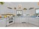 Well-lit kitchen with white cabinetry, tile floors, modern appliances, and breakfast nook at 3339 Desoto Dr, Punta Gorda, FL 33983