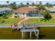 Aerial of a single-story home with a screened-in pool area and boat lift, ideal for Florida living at 400 Coronado Dr, Punta Gorda, FL 33950