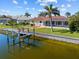 A waterfront property with a boat lift, lush lawn, and a screened pool, offering a perfect blend of relaxation at 400 Coronado Dr, Punta Gorda, FL 33950