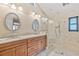 Bathroom featuring a double sink vanity and walk-in shower with glass enclosure at 400 Coronado Dr, Punta Gorda, FL 33950