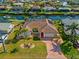 Beautiful home with a brick driveway, well-maintained lawn, mature palms, and lush landscaping at 400 Coronado Dr, Punta Gorda, FL 33950