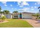 Charming home with a well-manicured lawn, brick driveway, and beautiful tropical landscaping at 400 Coronado Dr, Punta Gorda, FL 33950