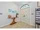 Light-filled foyer featuring a decorative table, neutral tile flooring and whimsical starfish adorned closet doors at 400 Coronado Dr, Punta Gorda, FL 33950