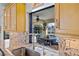 Kitchen view featuring granite countertops, modern sink fixtures, and a pass-through window to the outdoor patio and pool at 400 Coronado Dr, Punta Gorda, FL 33950