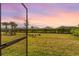 Screened patio overlooking a spacious backyard with lush landscaping at 43104 Lakeside Way, Punta Gorda, FL 33982