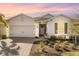 White house with a two-car garage, landscaping, and a welcoming porch at 43104 Lakeside Way, Punta Gorda, FL 33982