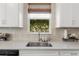 Modern kitchen with white cabinets, quartz countertops, and a farmhouse sink at 43104 Lakeside Way, Punta Gorda, FL 33982