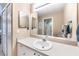 Well-maintained bathroom with a single sink vanity, large mirror, and shower with glass door at 5738 Sabal Trace Dr # 204B57, North Port, FL 34287