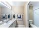 Bright bathroom with a single sink vanity, a large mirror and a toilet located within the shower room at 5738 Sabal Trace Dr # 204B57, North Port, FL 34287