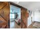 Cozy bedroom featuring a comfortable couch, wood floors, and sliding barn door access at 5738 Sabal Trace Dr # 204B57, North Port, FL 34287