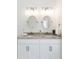 Double vanity bathroom with granite countertop and oval mirrors at 706 W Madison St, Plant City, FL 33563
