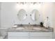 Double vanity bathroom with granite countertop and oval mirrors at 706 W Madison St, Plant City, FL 33563