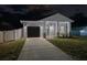 Night view of craftsman home with teal door and garage at 706 W Madison St, Plant City, FL 33563