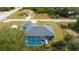 Aerial view of the property featuring a screened pool, a large gray roof, and a storage shed in the backyard at 9 Logan St, Port Charlotte, FL 33954