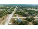 Bird's eye view of the property showcasing a screened pool and a large gray roof in a lush green neighborhood at 9 Logan St, Port Charlotte, FL 33954