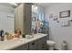 Bright bathroom with a double vanity, white counters, gray cabinets, and a large mirror at 9 Logan St, Port Charlotte, FL 33954