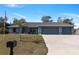 Inviting home with a lush lawn, mature landscaping, and a spacious three-car garage, creating a welcoming curb appeal at 9 Logan St, Port Charlotte, FL 33954