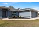 Charming home featuring a well-maintained lawn, colorful landscaping, and an attached two-car garage for convenient parking at 9 Logan St, Port Charlotte, FL 33954