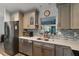 Well-lit kitchen with stainless steel appliances, breakfast bar, and views of the backyard at 9 Logan St, Port Charlotte, FL 33954