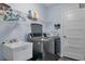 Modern laundry room with a front load washer and dryer, utility sink and wire shelving at 9 Logan St, Port Charlotte, FL 33954