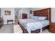 Bedroom featuring a bed with a patterned comforter, a dark wood dresser, and light gray carpet at 91 Vivante Blvd # 402/9142, Punta Gorda, FL 33950