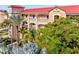 Attractive multi-story building with palm trees and manicured greenery, showcasing the exterior's elegance at 91 Vivante Blvd # 402/9142, Punta Gorda, FL 33950
