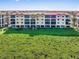Four-story condo building with lush green lawn extending out towards the ocean at 91 Vivante Blvd # 402/9142, Punta Gorda, FL 33950