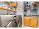 Laundry room featuring a washer and dryer, light wood cabinets, and organized storage at 91 Vivante Blvd # 402/9142, Punta Gorda, FL 33950