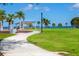 A relaxing view of a park with a winding path, lush lawn, palm trees, and waterfront at 91 Vivante Blvd # 402/9142, Punta Gorda, FL 33950