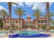 Resort style pool and clubhouse with tropical landscaping and blue tiled water feature at 91 Vivante Blvd # 402/9142, Punta Gorda, FL 33950